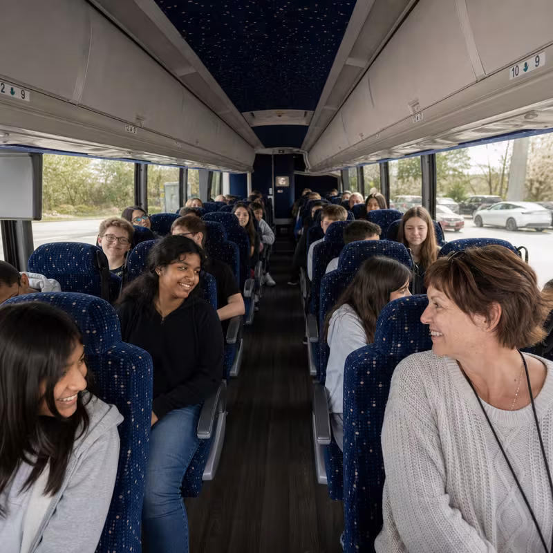 Group boarding a white charter bus for School Transportation transportation in Union