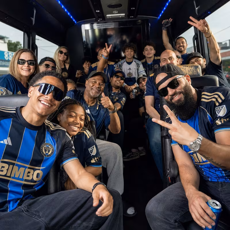 Group boarding a white charter bus for Sporting Event Transportation transportation in Union